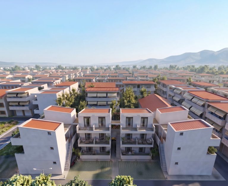 High aerial view of Victoria Residence at sunrise, symmetrical blocks among red-roofed town with hills behind