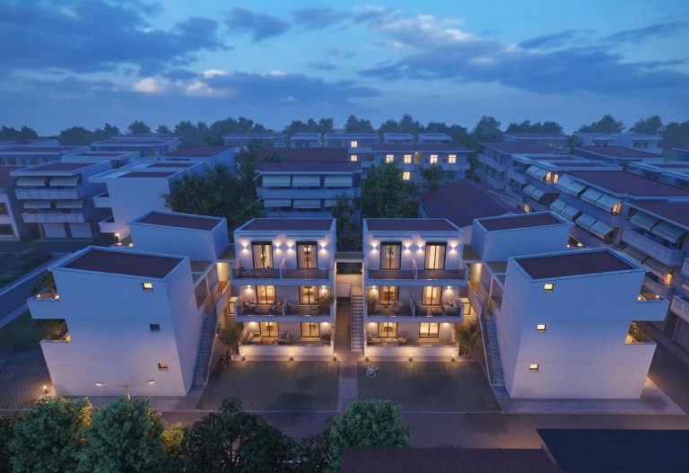 High aerial view of Victoria Residence at blue hour, the blocks around paved courtyards with lit balconies
