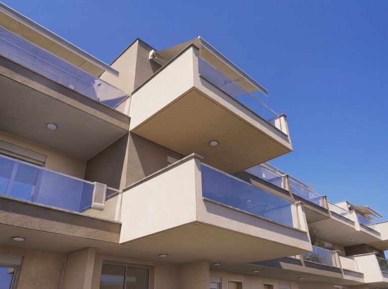 Catherina Residence low-angle view of cantilevered balconies with glass railings against a clear blue sky