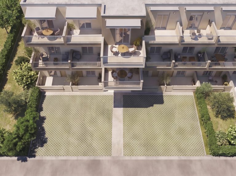 Aerial top-down view of Catherina Residence in soft daylight, stacked balconies above the grass-paver forecourt