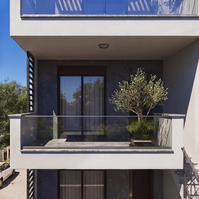 Nika 2 Residence: frontal close-up of a glass-railed balcony with an olive tree and sliding doors in daylight
