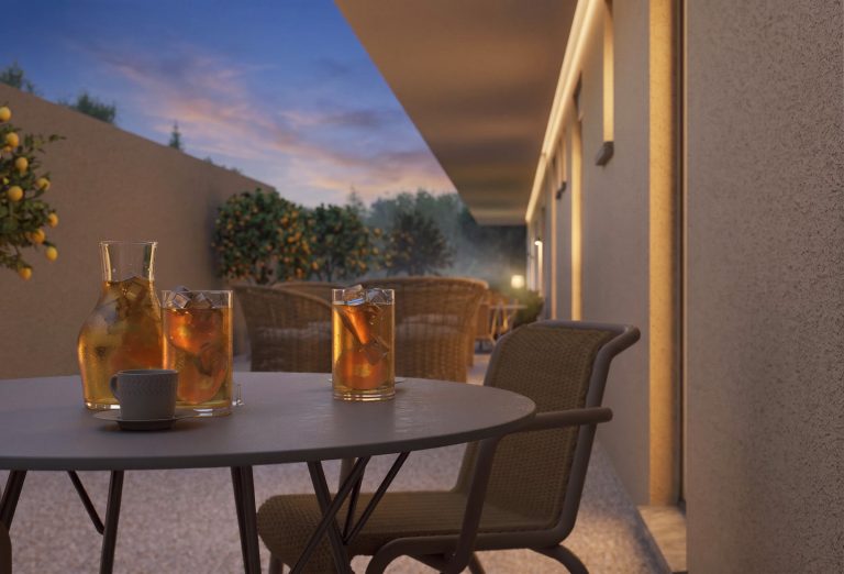 Catherina Residence courtyard table with iced drinks at dusk, wall grazing light and potted orange trees