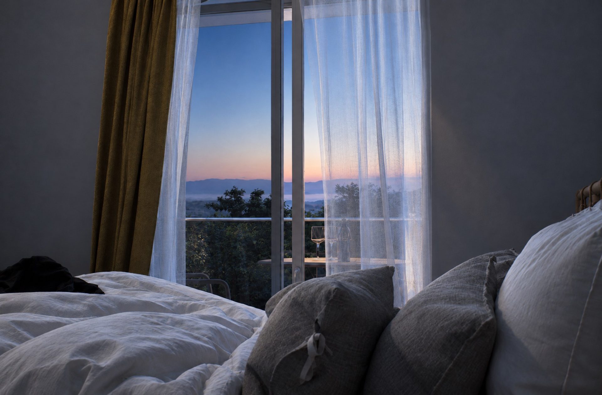 Olympia Residence bedroom at first light, peach glow over the hills, sheer curtains, lamps off