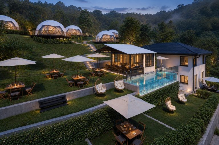 Elevated view of dining terraces, pool, pavilion and domes at dusk