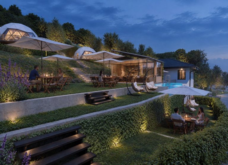 Lower terrace with steps, dining tables and domes on the slope at blue hour