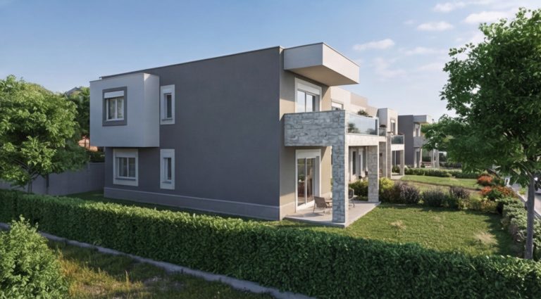 Sikia Vista end house side view in daylight, gray facade with stone-clad terrace behind a hedge and lawn