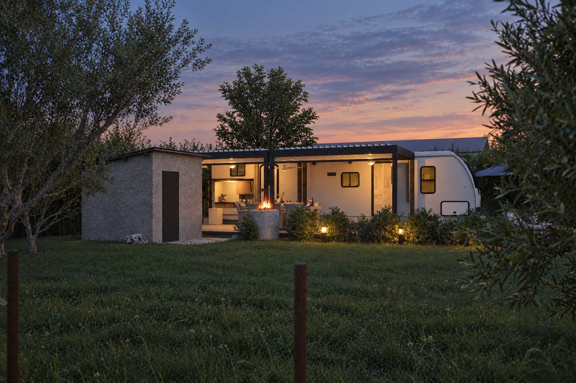 Camper, pergola and utility shed lit from within at blue hour across the lawn, fire pit burning