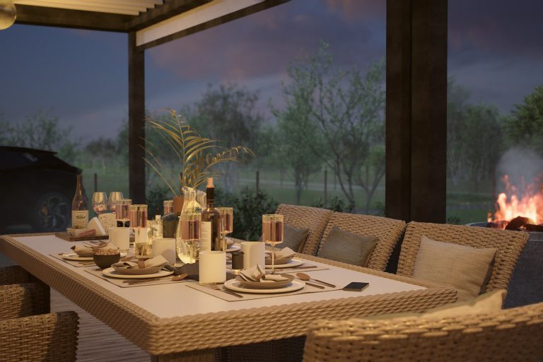 Dinner table under the pergola at dusk with the fire pit lit